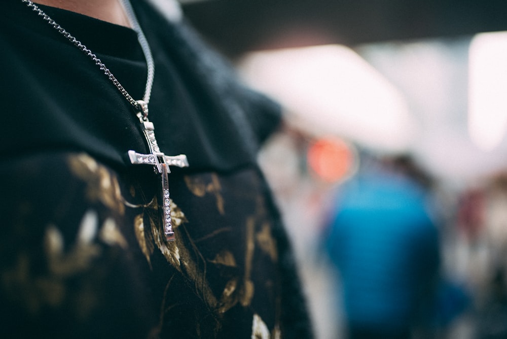 a person wearing a black shirt and a cross necklace