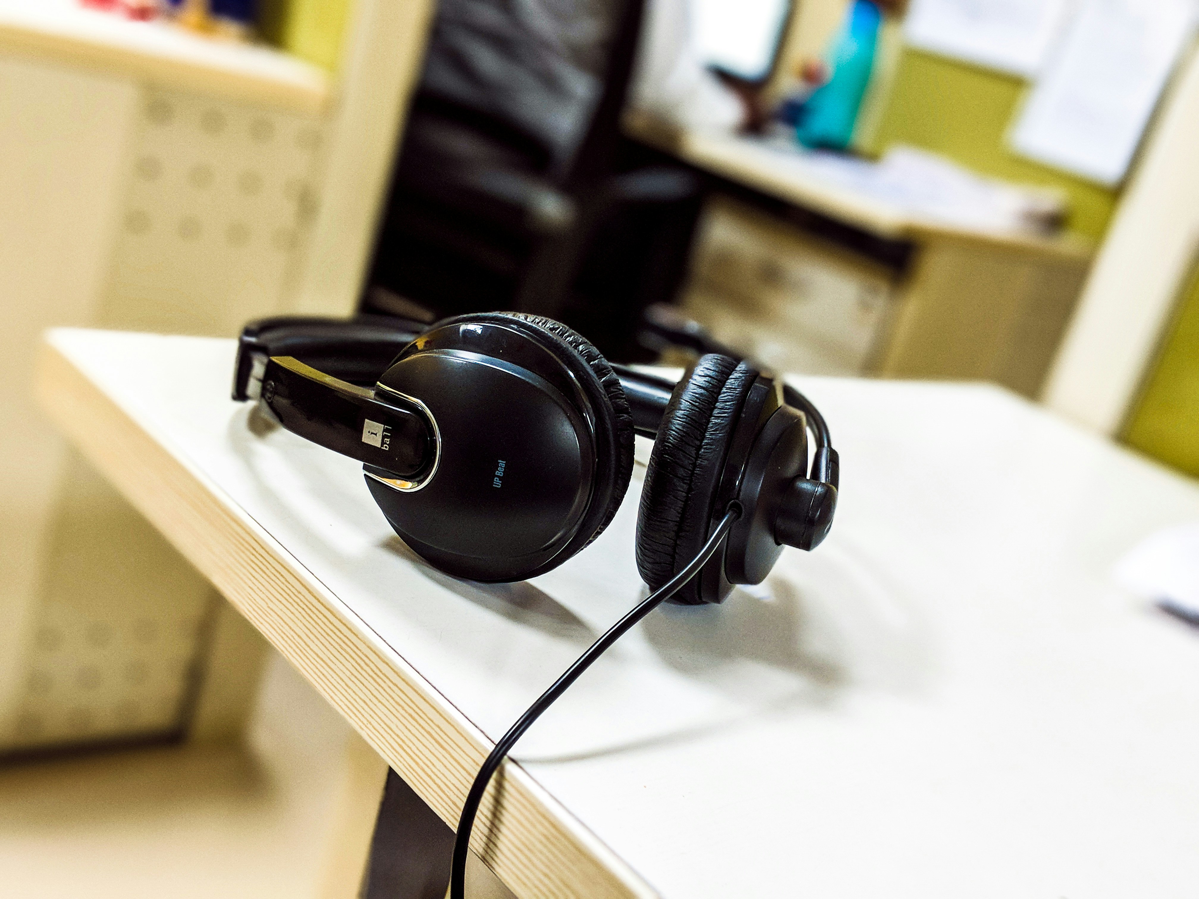 Black over-ear headphones on a dark desk, moody atmospheric lighting