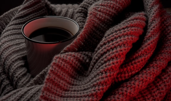 white cup on beige knitted cloth