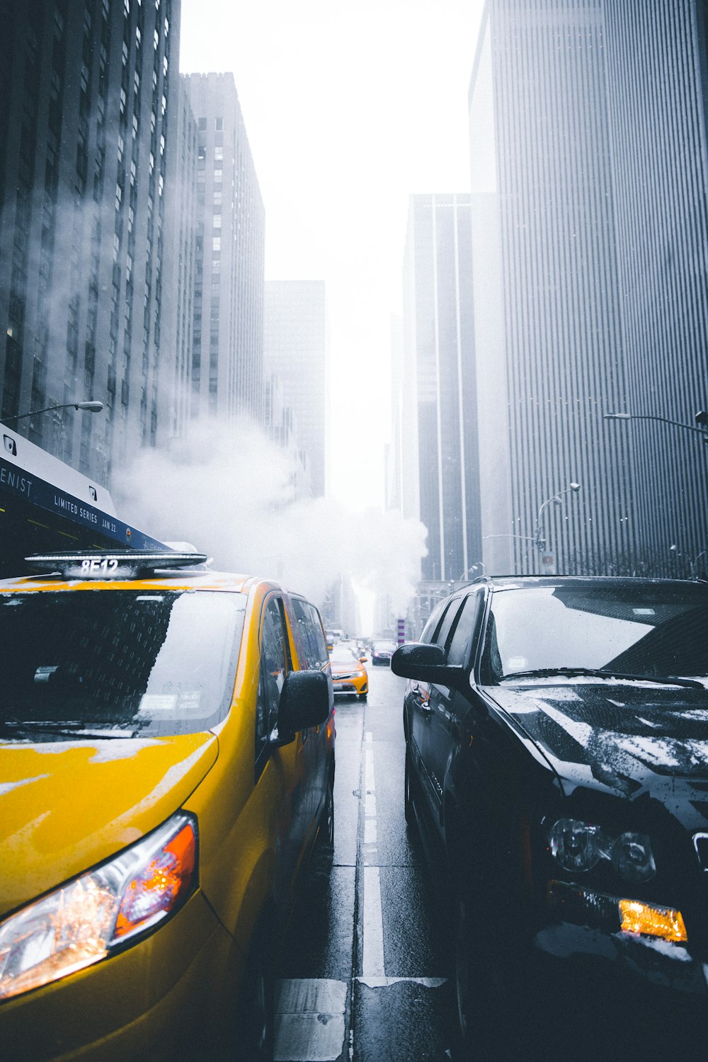 a city street filled with traffic next to tall buildings