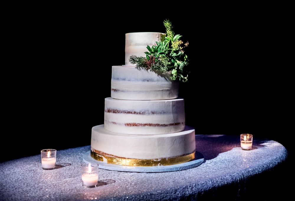 4-tier cake on top of gray table with three votive candles