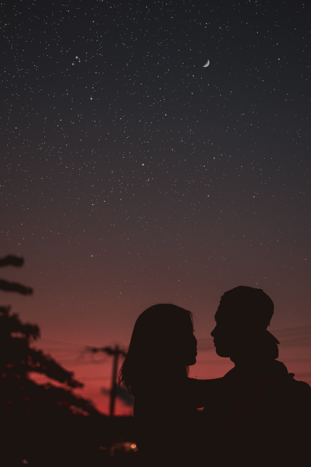 Silhouette einer Frau, die MNA unter dem Sternenhimmel umarmt