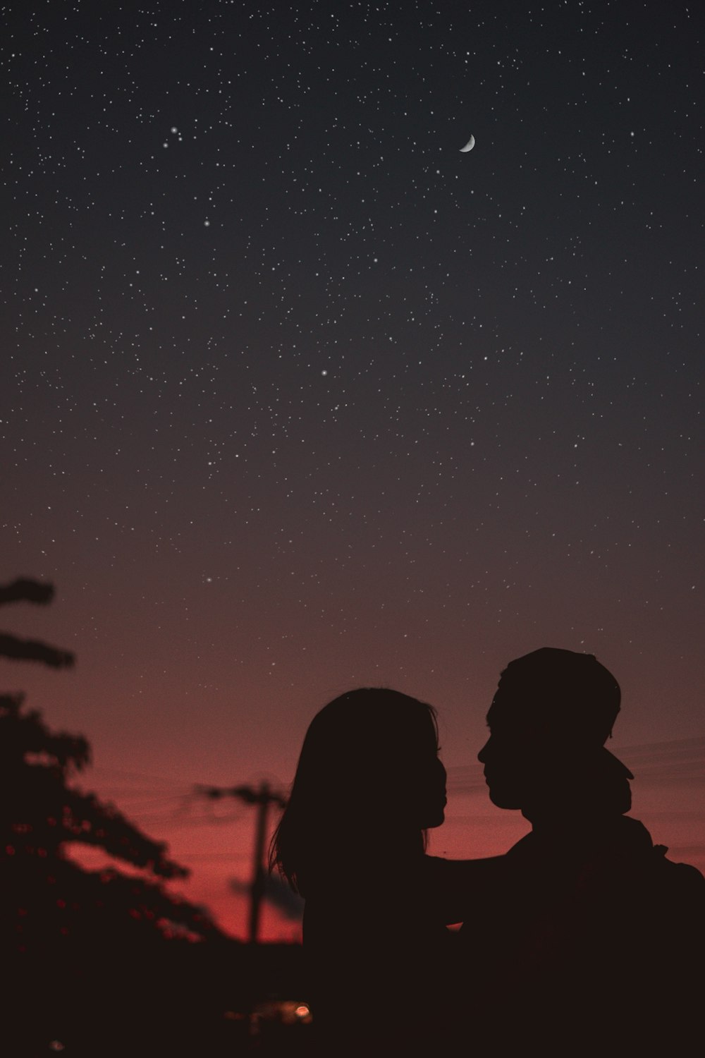 silhouette of woman hugging mna under starry night sky