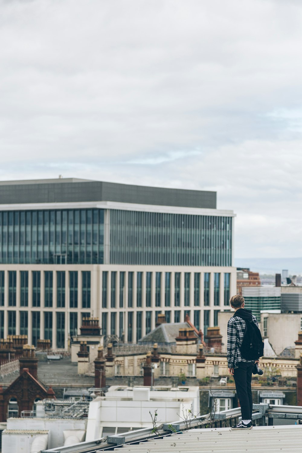 person with backpack standing on top of roof during daytime