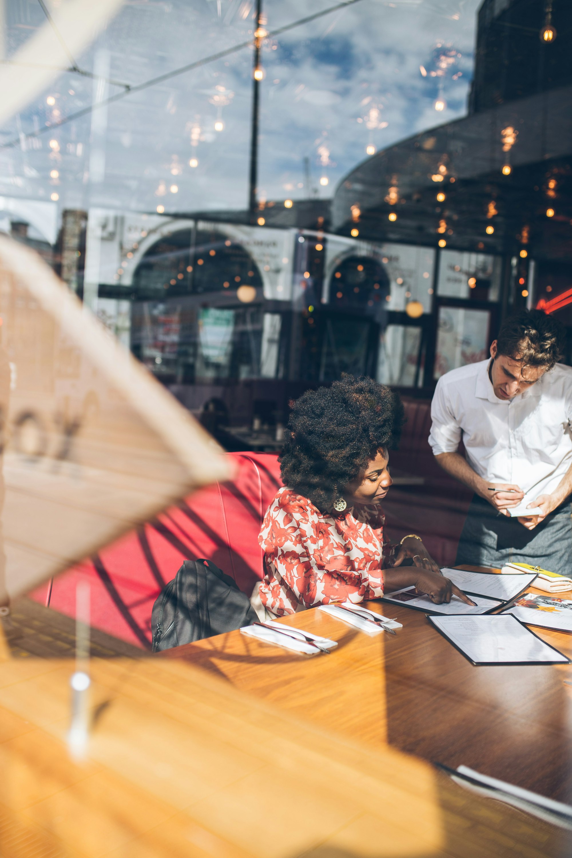 Guest in restaurant looking at menu designs and making a restaurant order.