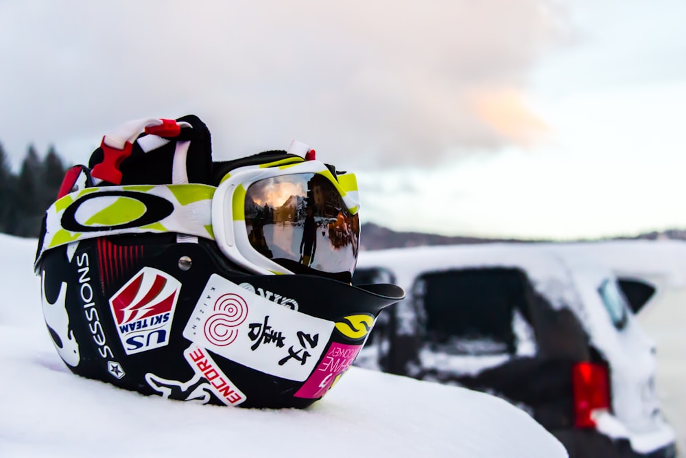 schwarzer und mehrfarbiger Helm auf Schnee