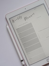 Close-up of hands organizing a colorful digital planner on a tablet.