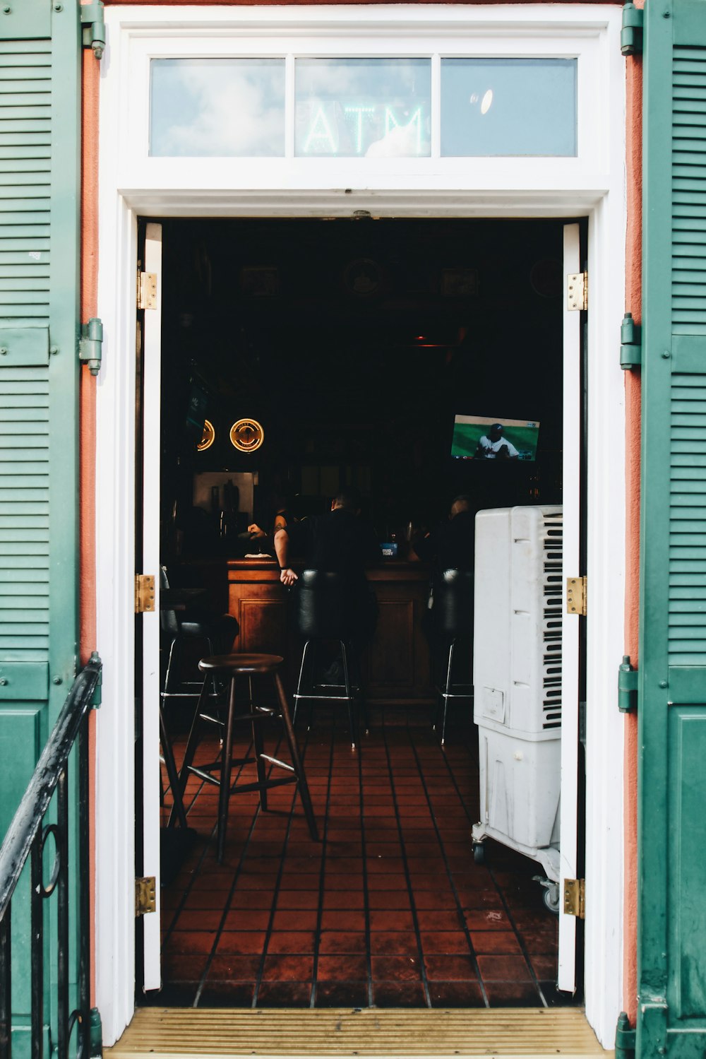 white wooden door open seeing TV and chairs inside