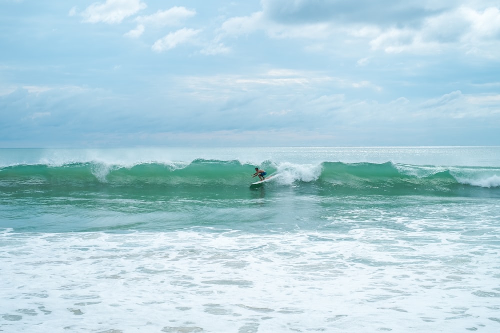 man surfing at the ocean during day