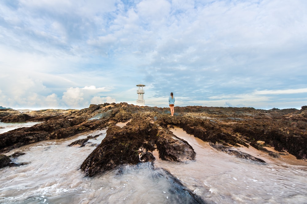 Photo d’une femme debout sur un rocher près d’un plan d’eau