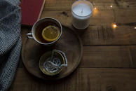 A rustic wooden table with herbal tea, a book, and pine branches arranged simply.
