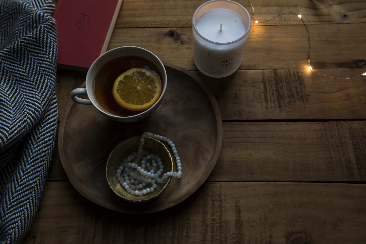 Cozy modern lifestyle setting with mug, candle and thoughtful home objects
