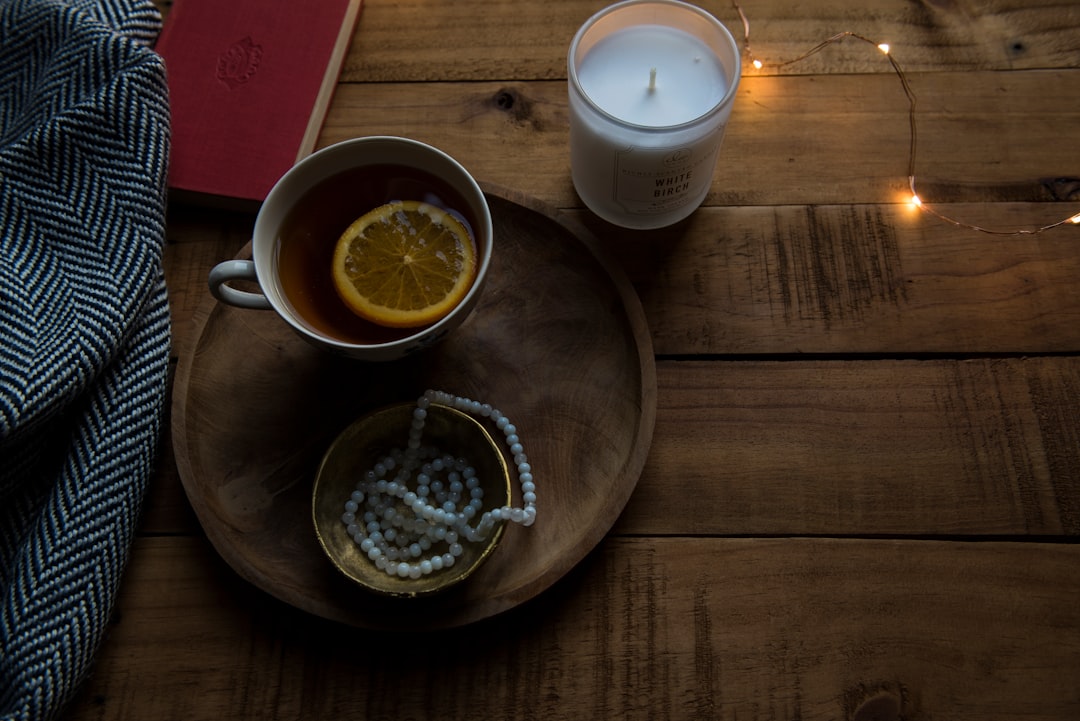 ceramic mug on wood tray near candle