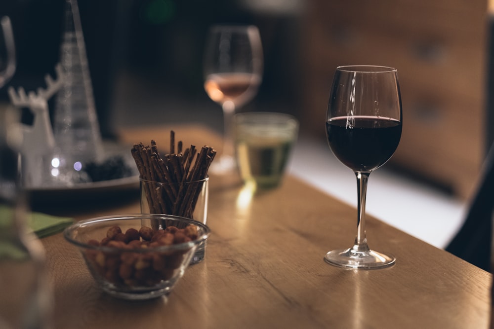 liquide noir dans un verre à vin transparent sur une table en bois brun