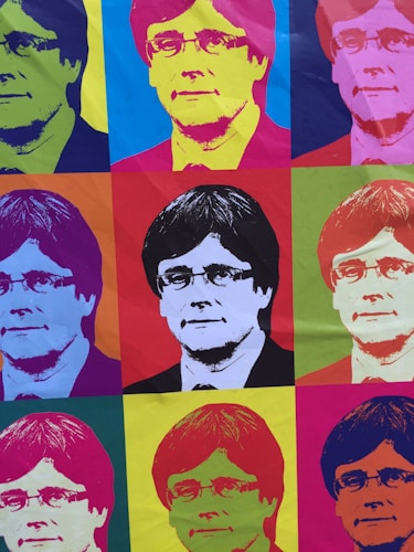 The image consists of a grid of nine portraits of the same person, each rendered in a style reminiscent of pop art. The portraits feature vibrant, contrasting colors with the subject positioned in the center of each section. The overall composition is colorful and visually striking, showcasing a variety of hues in each individual square.