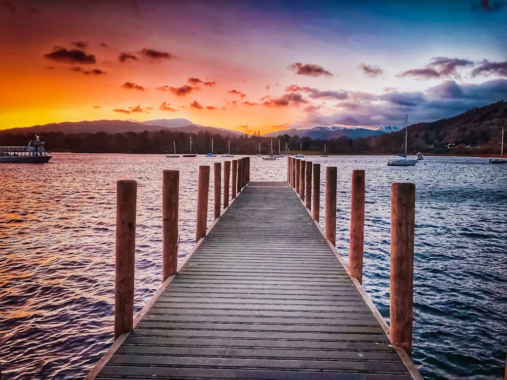 Muelle de madera marrón cerca del cuerpo de agua durante la hora azul