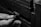 A close-up of hands manipulating a combination lock embedded in a textured, rugged surface, possibly a safe or chest.