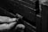 A close-up of hands manipulating a combination lock embedded in a textured, rugged surface, possibly a safe or chest.