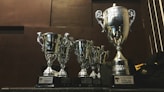 several silver and gold trophies on wooden surface
