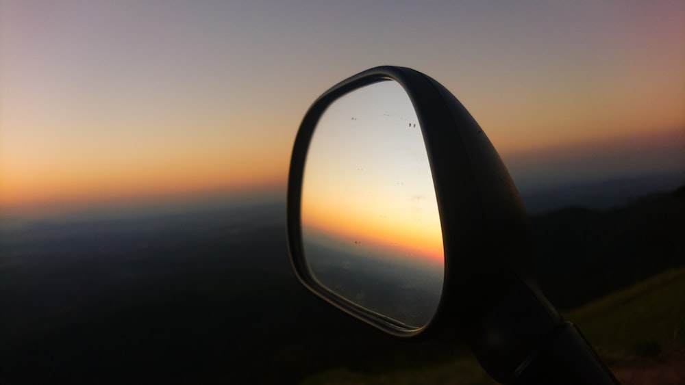 selective focus photo of vehicle side mirror during golden hour