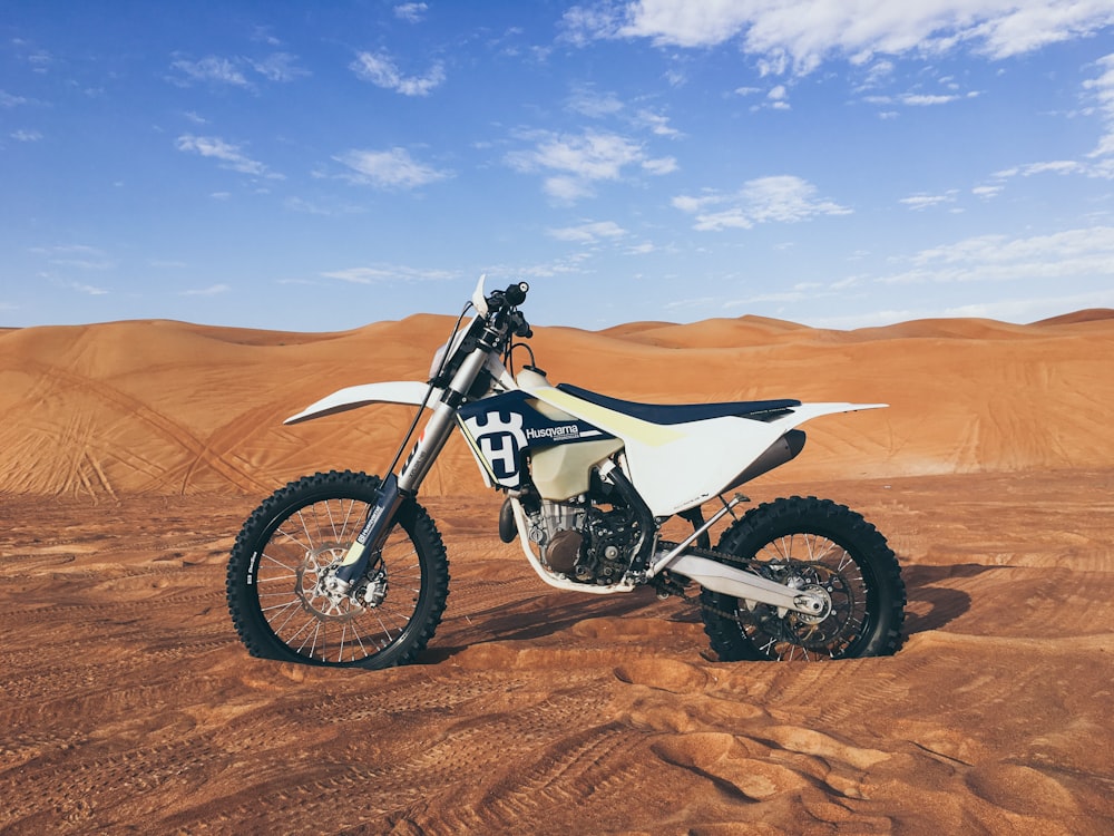 black and white dirt bike on sand