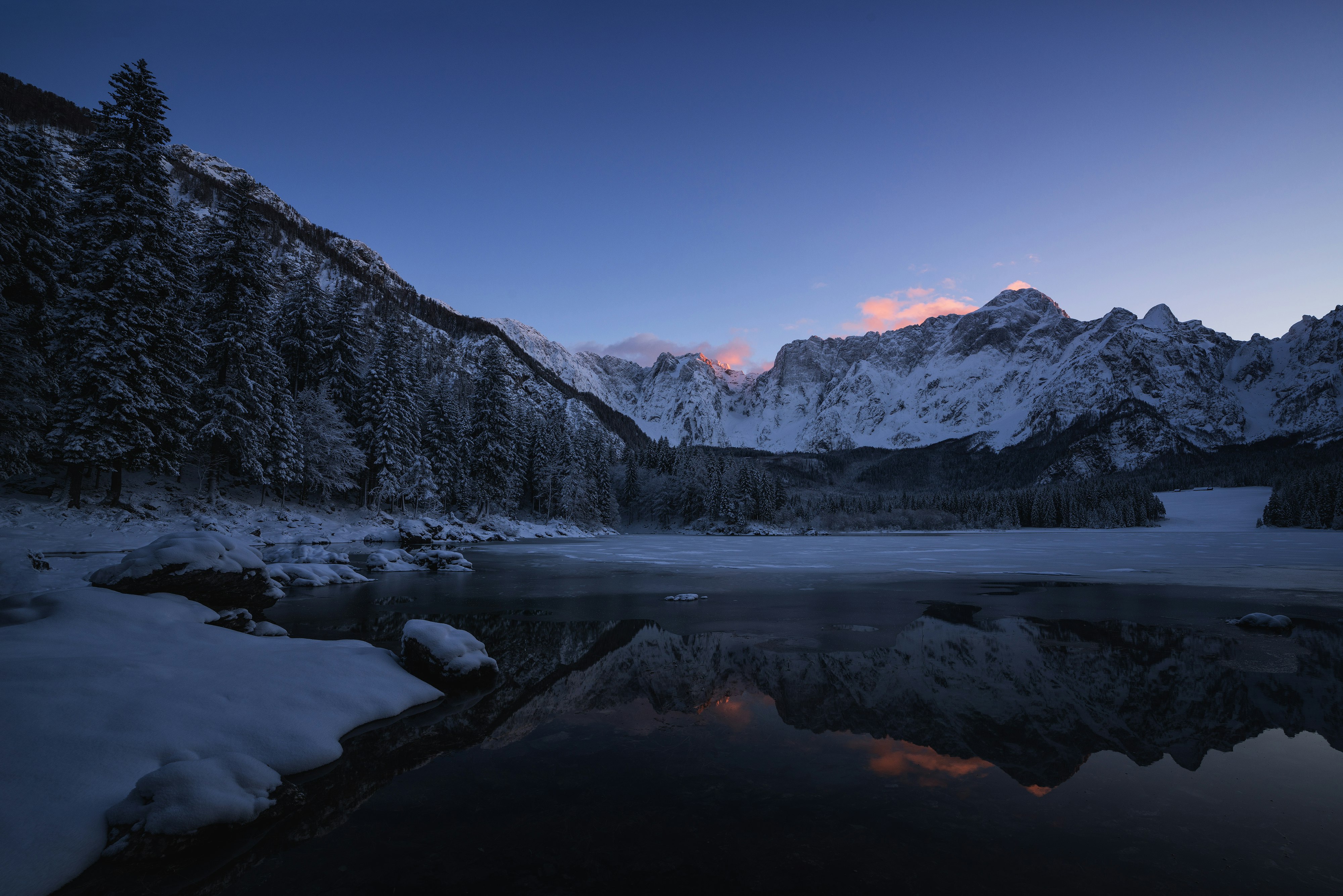 body of water near mountain at dawn