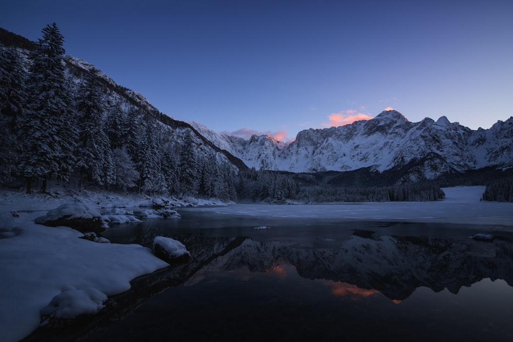 body of water near mountain at dawn