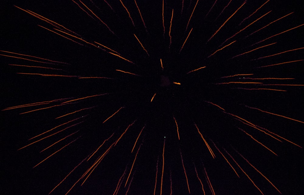 a black and red photo of fireworks in the night sky