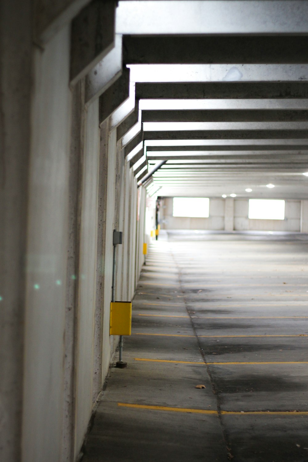 an empty parking garage with yellow and white signs