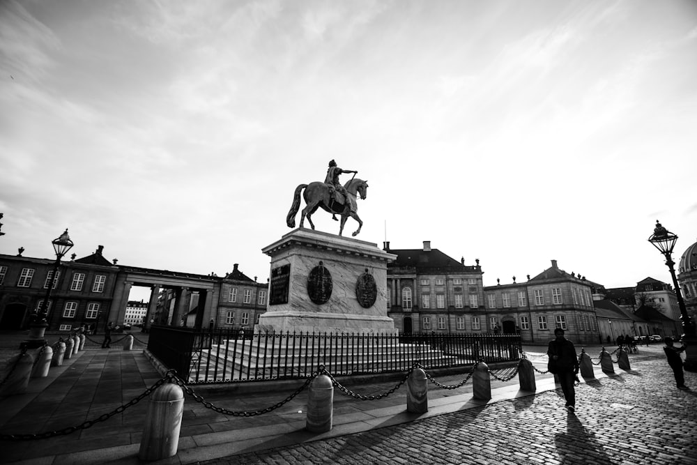 grayscale photo of man riding horse statue