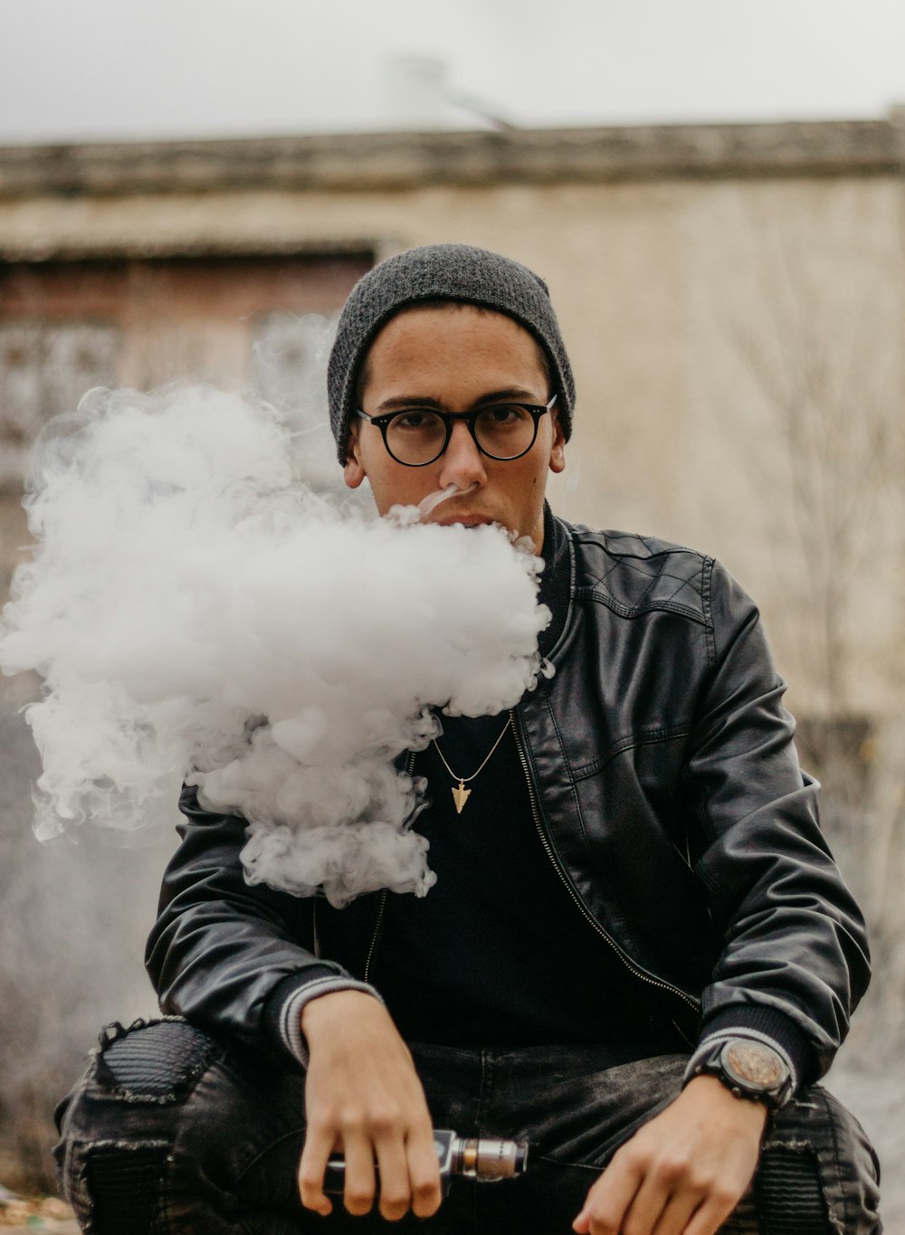 セレクティブフォーカス写真で蒸気を吸いながら座っている男性