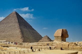 A scenic view of the Pyramids of Giza under a clear blue sky.