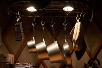 A sturdy hanging pot rack displaying various pots and pans above a kitchen island.