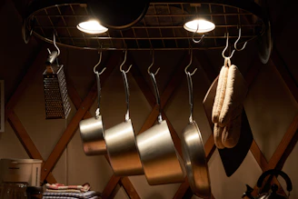 A sleek multi-tier kitchen storage rack neatly holding pots, pans, and utensils in a bright kitchen.