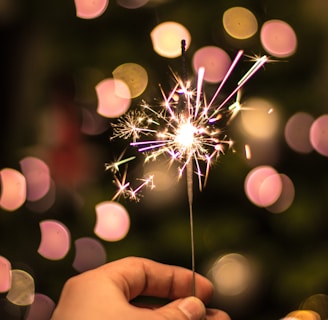 bokeh photography of person holding fireworks