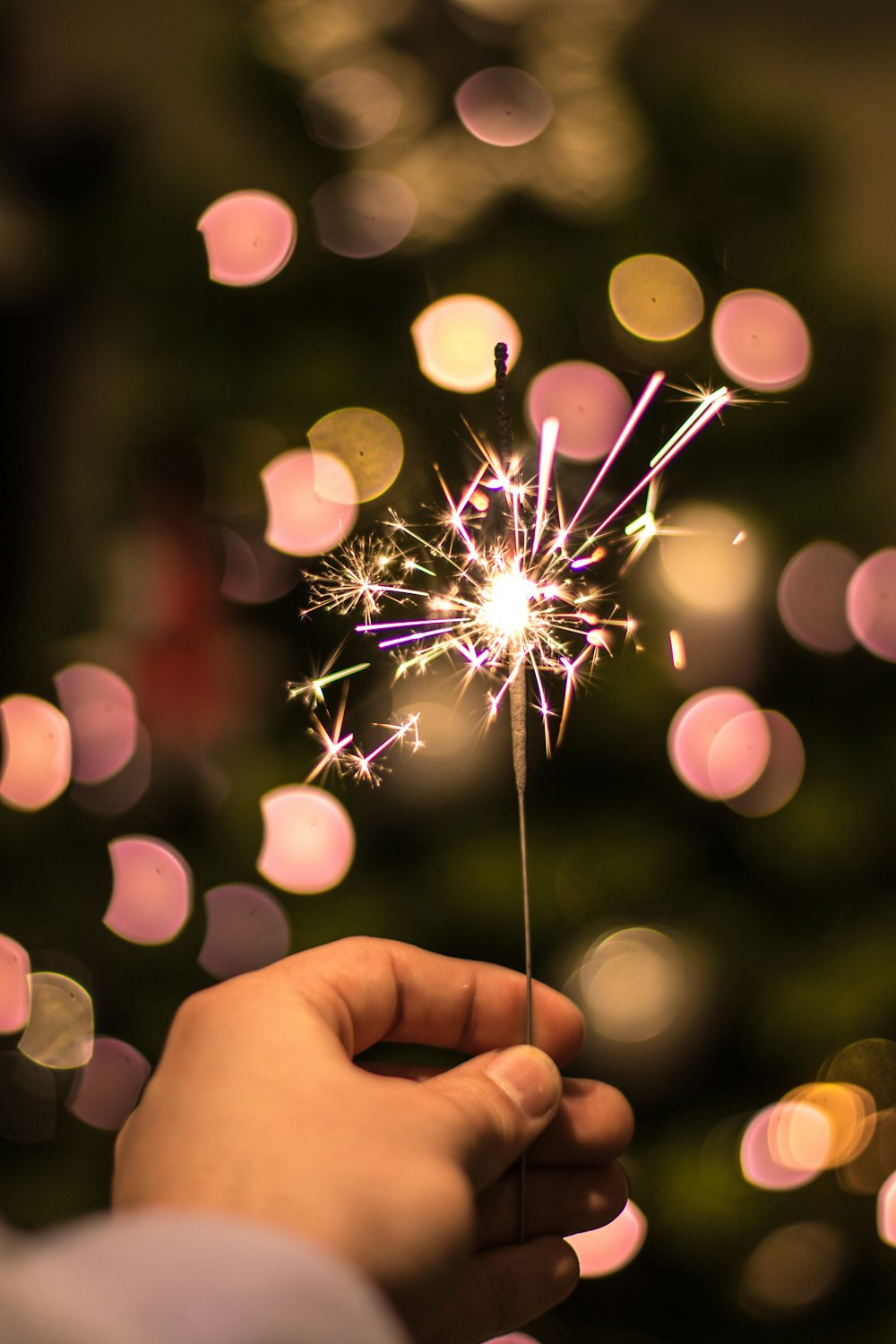 Bokeh-Fotografie einer Person, die Feuerwerkskörper hält