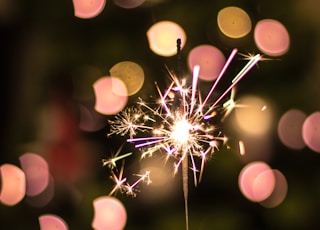 bokeh photography of person holding fireworks