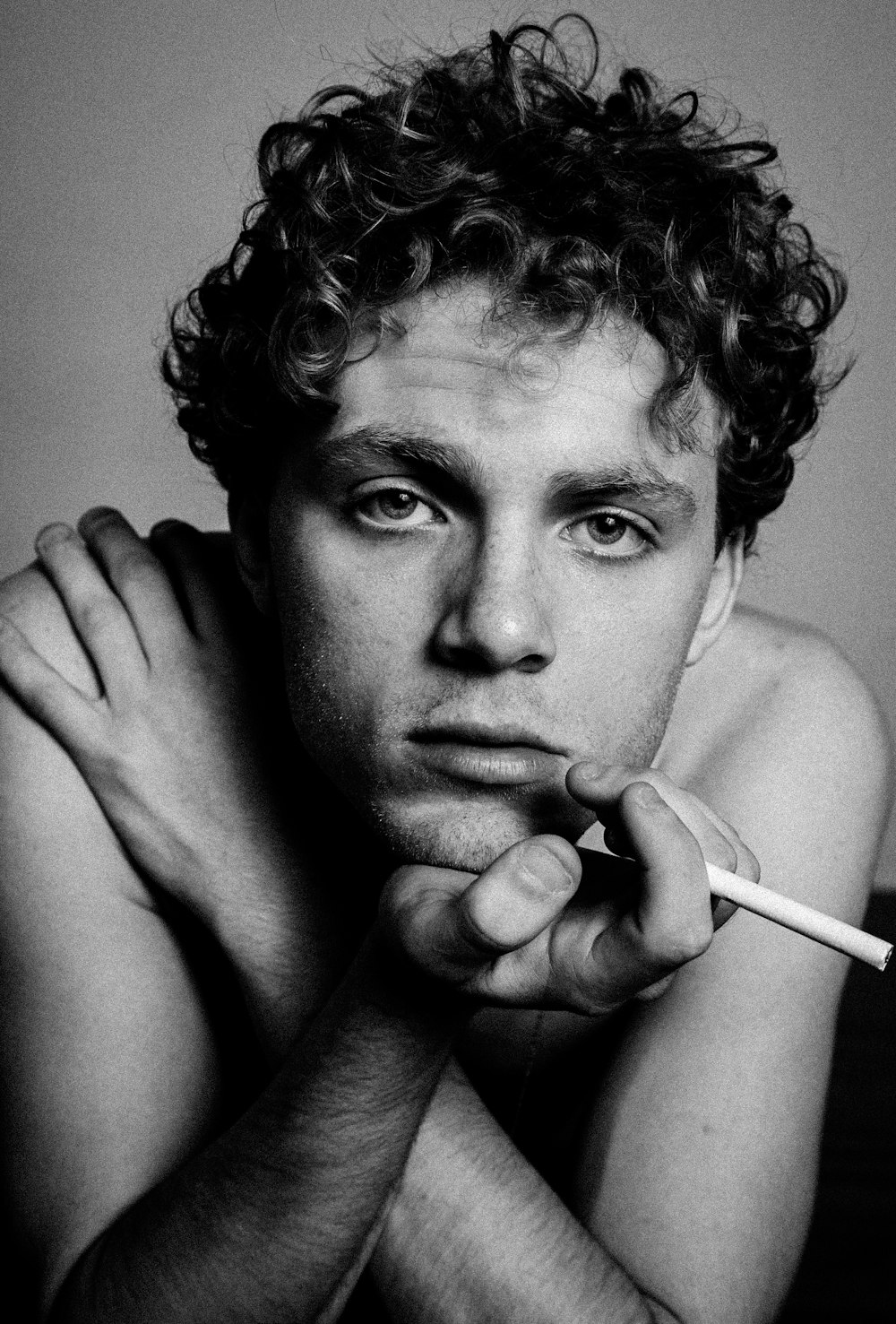 gray scale photo of man holding cigarette