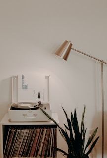 white turntable on white wooden organizer with vinyl record sleeves