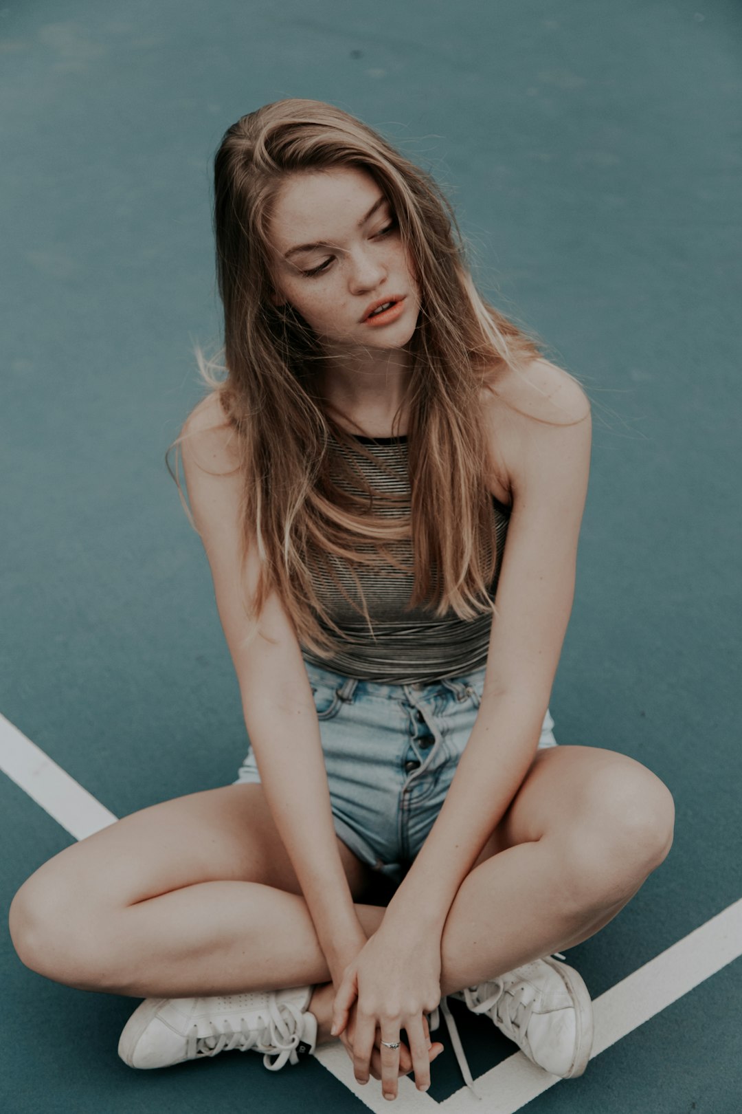 photo of blonde-haired woman sitting on floor