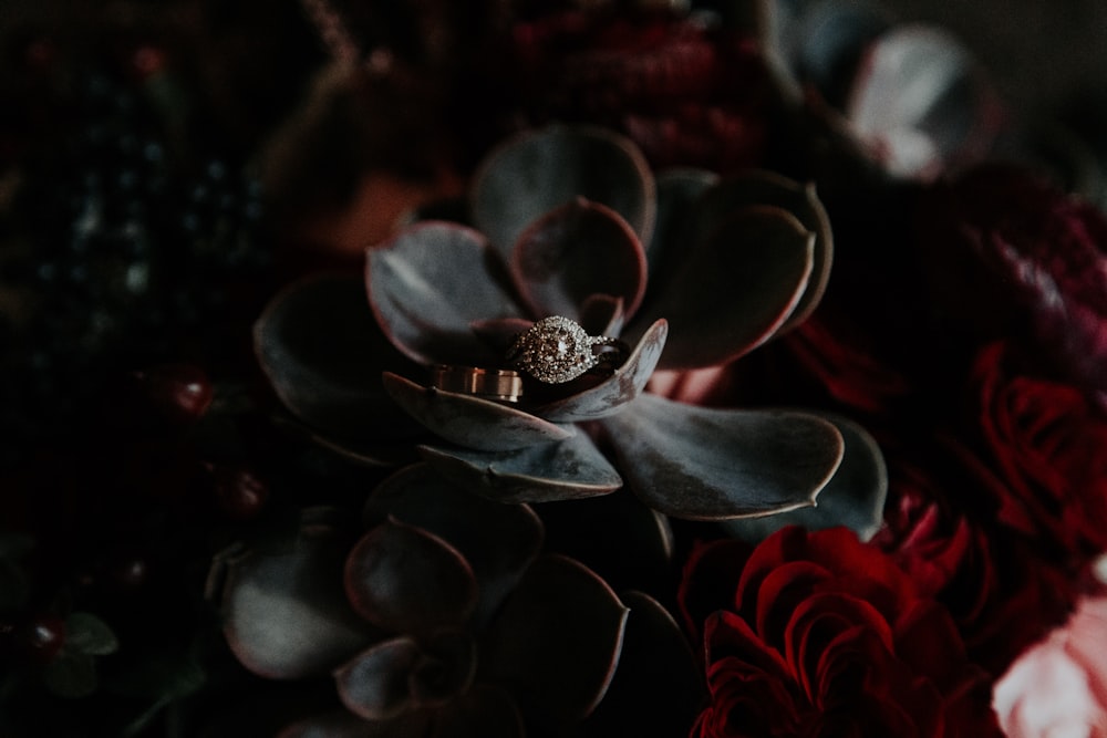 a wedding ring sitting on top of a flower