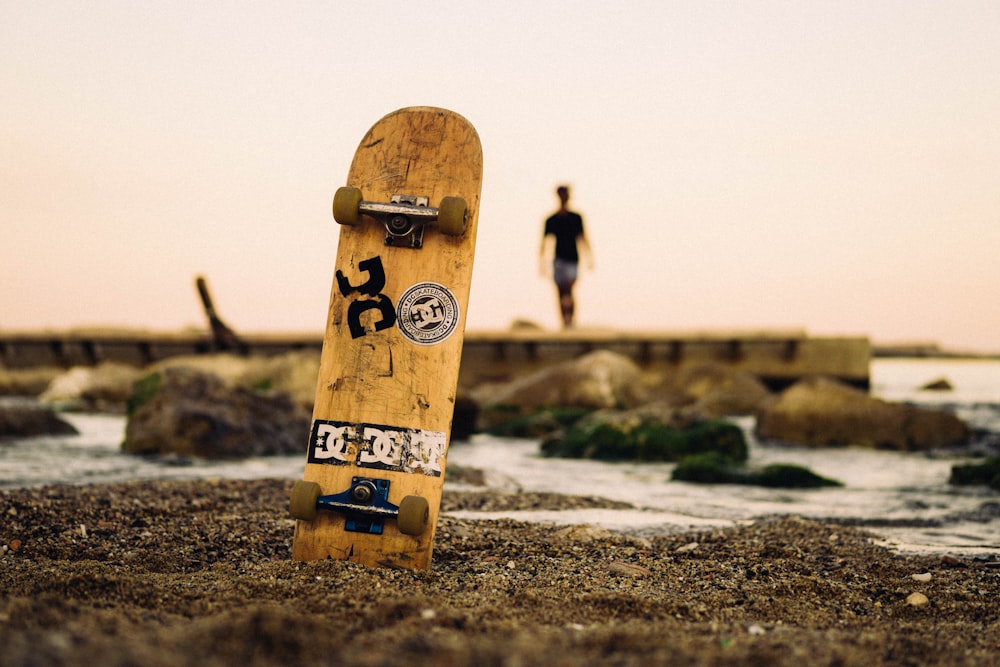 海岸線近くの茶色のスケートボードの選択焦点写真