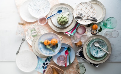 top-view artichoke and round orange fruits on piled plates
