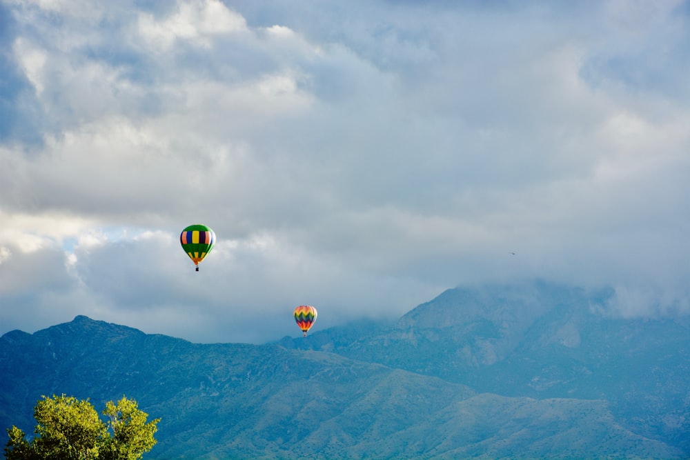 two hot air balloons near mountain