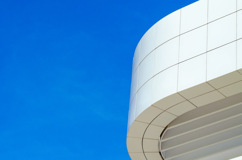 um edifício branco com um céu azul no fundo