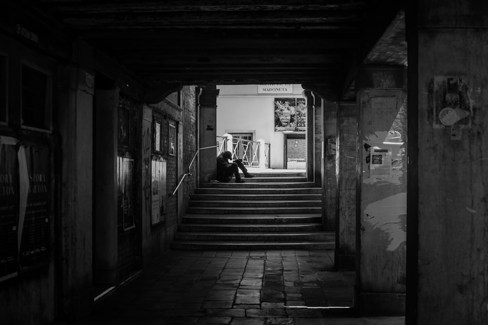 person sitting on gray stairs