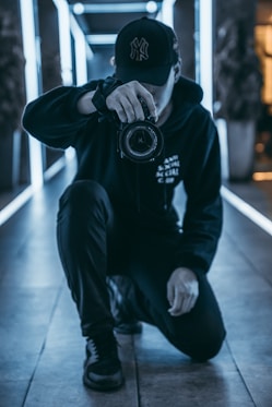 man taking camera while taking picture inside building