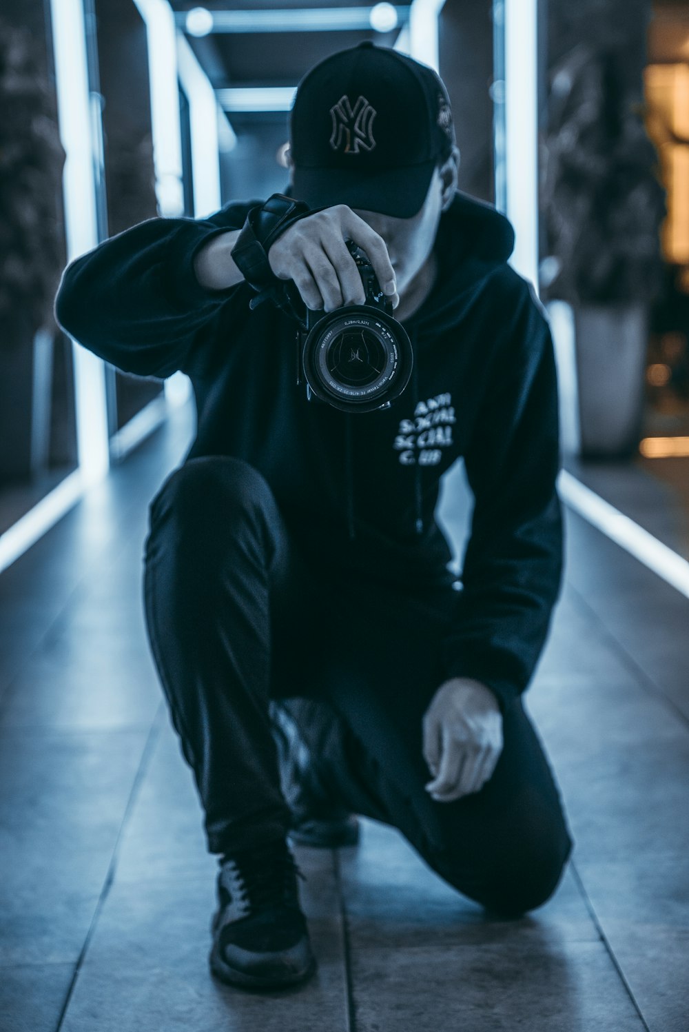 man taking camera while taking picture inside building