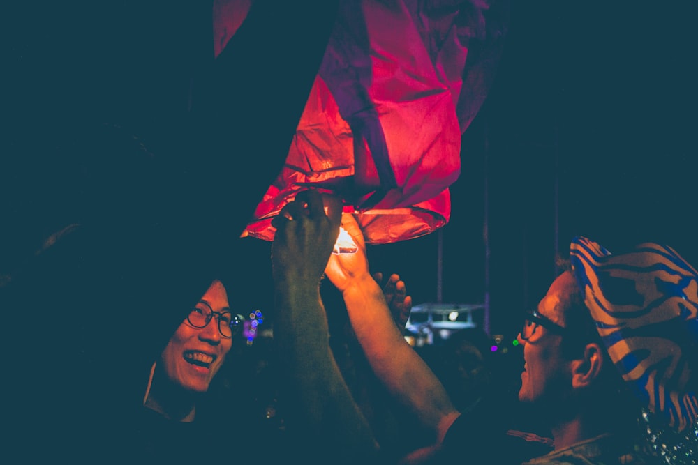 man lighting sky lantern during nighttime