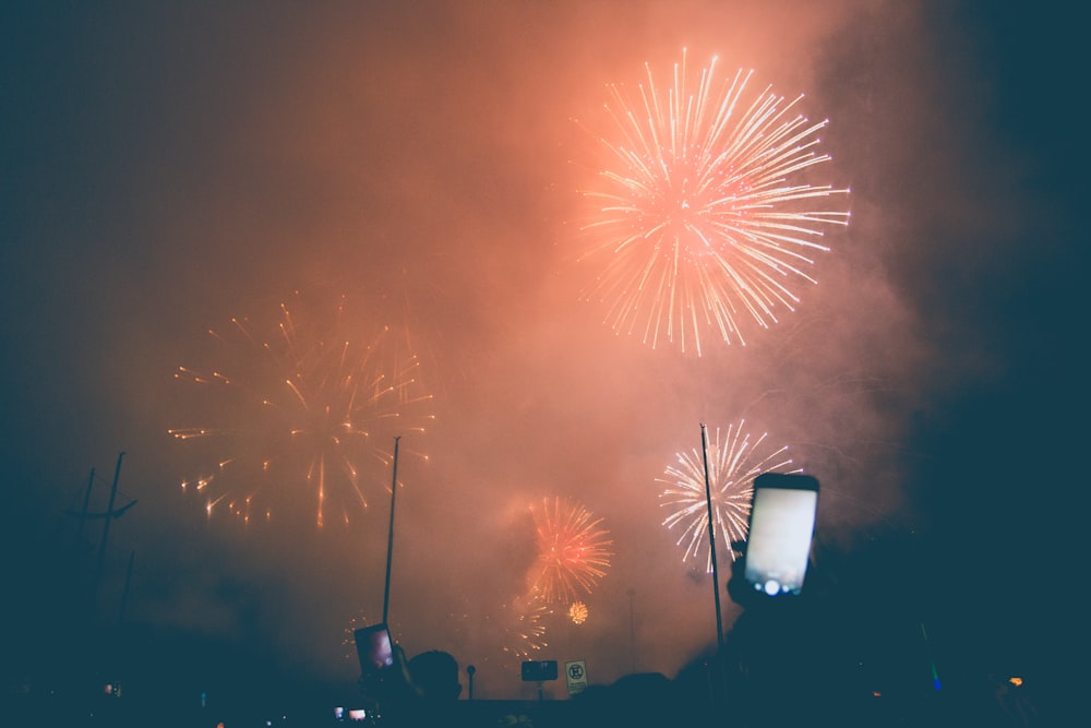 group of person taking photo and video on firecrackers